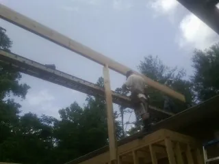 Carpenter setting a ridge beam over a new addition frame — Ice Dam Removal by Roofing Brothers in Hampton